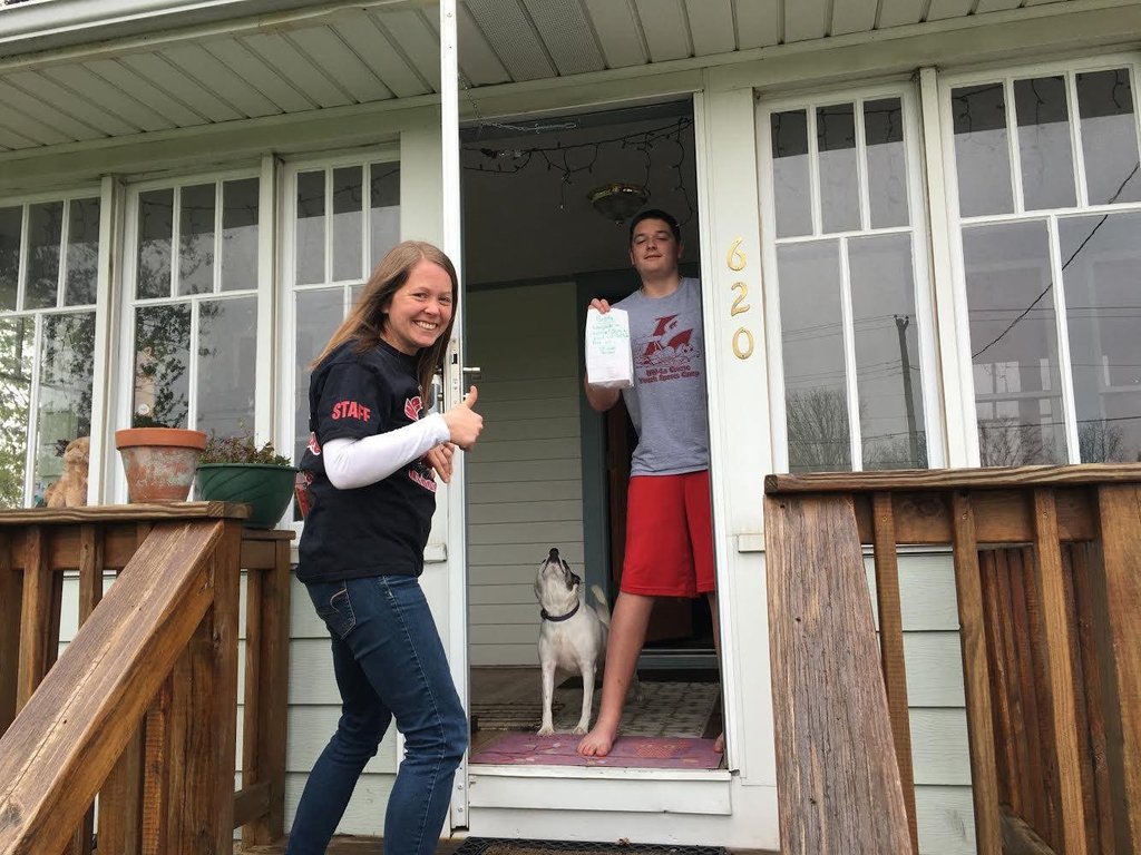 A Westby staff member and student pose with his prize on the student's front porch.