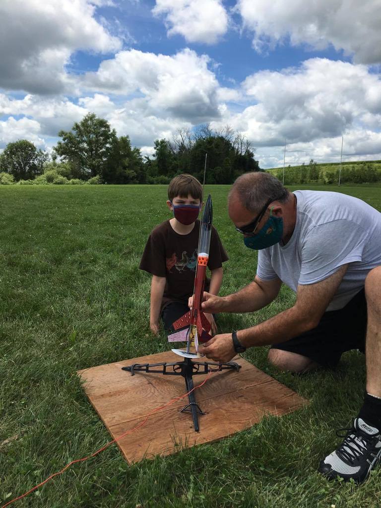 Student and teacher preparing rocket for launch